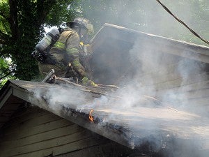 Vicksburg firefighters prepare to enter the attic of a burning home at 1114 Adams Lane Monday.