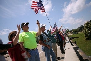 Vicksburg residents wave to the procession of motorcycles.