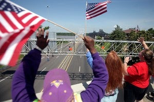 Vicksburg residents wave to the procession of motorcycles.