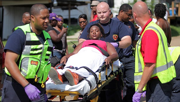 Vicksburg firefighters treat a woman who was shot in the leg Tuesday at Smiths Alley, near the corner of Halls Ferry Road and Bowmar Avenue. (Justin Sellers/The Vicksburg Post)