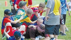 Campers dog pile volunteer Mike Grzanich Wednesday after a flag football game during Winshape Camp at Crossway Church. (Justin Sellers/The Vicksburg Post)