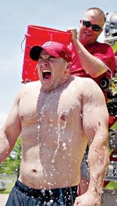 Firefighter Carl Kolb reacts as Fisher Ferry volunteer firefighter Joshua Davies dumps a bucket of ice water on him in the Cold Water Challenge Friday at Fire Station 8. (Justin Sellers/The Vicksburg Post)