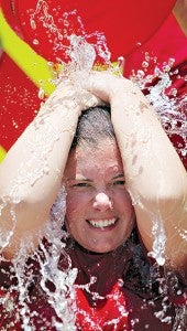 Fisher Ferry volunteer firefighter Kelly Collier covers her head as ice water is dumped on her in the Cold Water Challenge Friday at Fire Station 8. (Justin Sellers/The Vicksburg Post)