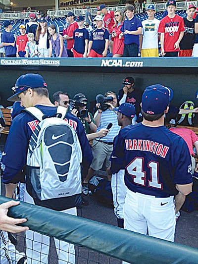 Ole Miss players Scott Weathersby and Preston Tarkington (41) stand in the dugout as fans clamor for autographs at the end of Friday’s College World Series practice at TD Ameritrade Park in Omaha, Neb. (Ole Miss Sports Information)
