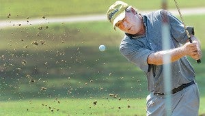 Jeff Cowan, blasts out of the sand trap and on the green at the 9th hole.