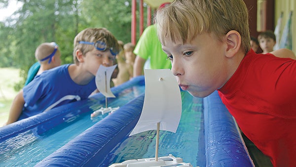 Wesley Cowan, 8, right, competes in a Rain Gutter Regatta race against Travis Webb, 8, left, during Boy Scouts of America day camp held this week at the Knights of Columbus Hall on Fisher Ferry Road. (Justin Sellers/The Vicksburg Post)