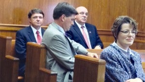 State Auditor Stacey Pickering checks his phone while waiting to speak to Warren County supervisors Monday. Seated near Pickering are, from left, District Attorney Ricky Smith, OSA investigator Jay Strait and Special Assistant Attorney General Melissa Patterson. (Danny Barrett Jr. / The Vicksburg Post)