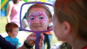 Vicksburg native Gracie Griggs, 8, checks out her face paint done by Sherry Burdsal, owner of Fancy Faces, Saturday morning at the Fall Festival downtown. (Justin Sellers/The Vicksburg Post)