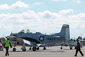 Visitors walk by a restore Navy VT-5 airplane Friday during the Southern Heritage Air Show at Vicksburg-Tallulah Regional Airport. (Justin Sellers/The Vicksburg Post)