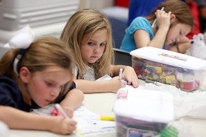 Ella Kate Boone, 7, from left, Emory Broadfoot, 6, and Hope Hudson, 11, color in drawings Wednesday night to be put inside their shoeboxes for needy children as part of Operation Christmas Child at First Baptist Church. (Justin Sellers/The Vicksburg Post)