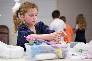 Ella Kate Boone, 7, packs a shoebox full of toys and candy Wednesday night for a needy child as part of Operation Christmas Child at First Baptist Church. (Justin Sellers/The Vicksburg Post)