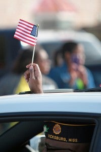 A veteran waves a flag through the sunroof of his car Tuesday morning during the annual Veterans Day parade on Washington Street in downtown Vicksburg. (Justin Sellers/The Vicksburg Post)