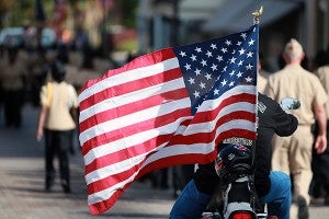 A motorcycle rider flies the American flag Tuesday morning during the annual Veterans Day parade on Washington Street in downtown Vicksburg. (Justin Sellers/The Vicksburg Post)