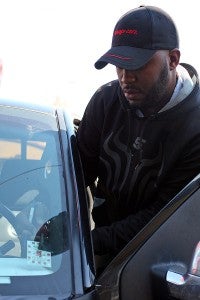 Manager Joseph Fisher scrapes of an inspection sticker Thursday morning at Texaco Xpress Lube on Clay Street. (Justin Sellers/The Vicksburg Post)