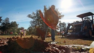 John Nickerson moves dirt onto a grave at Greenlawn Gardens Cemetery. (Justin Sellers/The Vicksburg Post)