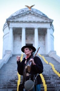 IN CHARACTER: Pat Strange, dressed as Union soldier Albert Cashier, speaks to a group of visitors at the base of the Illinois Memorial Saturday evening during the Shadows of the Past candlelight tour at the Vicksburg National Military Park.