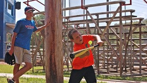 Brayson Morson, 9, bunts at a golf ball while Warren Central baseball player Brett Oldenburg watches Wednesday during WC’s annual “Home of Champions” baseball camp at Viking Field. The weeklong camp concludes on Thursday. (Ernest Bowker/The Vicksburg Post)