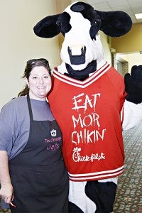 PHOTO OP: Margie Heltzel takes a moment to pose for a photo with the Chick-fil-A cow Tuesday.