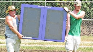 Randy Vinzant, left, and Charles Harper, employees with Southeastern Sign Co. of Madison, lift a new 25-second clock that was installed Wednesday at St. Aloysius’ Balzli Field. The school also had a new scoreboard installed. (Ernest Bowker/The Vicksburg Post)