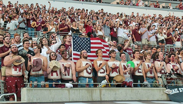 Fans stand during the National Anthem prior to a game between the